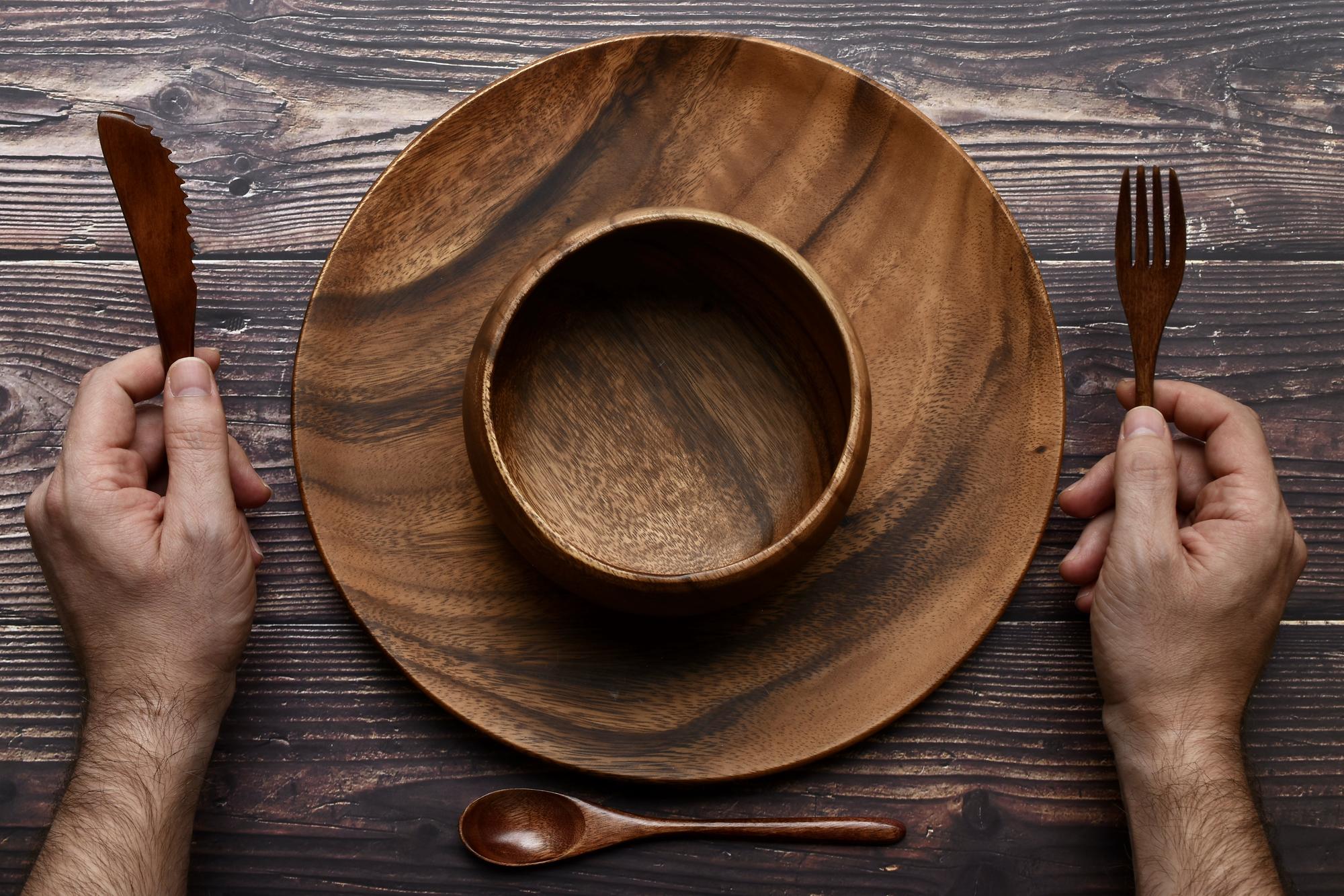 chef arranging a composed bowl on wooden table